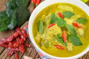 Free photo green curry in a bowl with lime, red onion, lemon grass, garlic and kaffir lime leaves