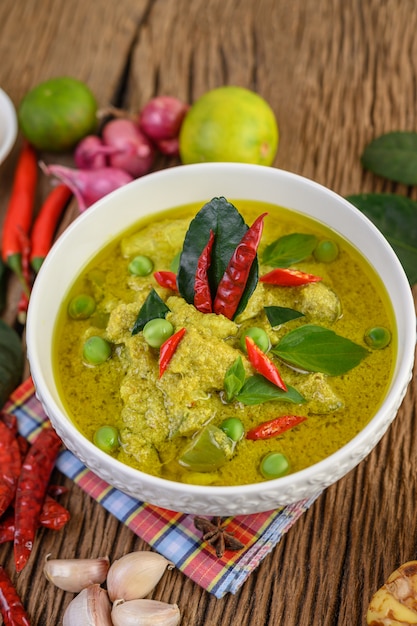Free photo green curry in a bowl with lime, red onion, lemon grass, garlic and kaffir lime leaves