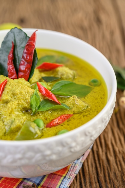 Free photo green curry in a bowl on wooden table.