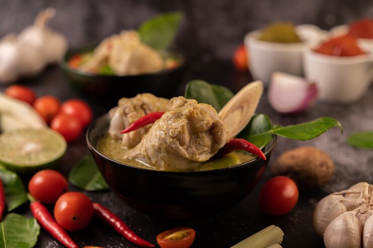 Free Photo green curry made with chicken, chili, and basil, with tomato, lime, kaffir lime leaves and garlic.