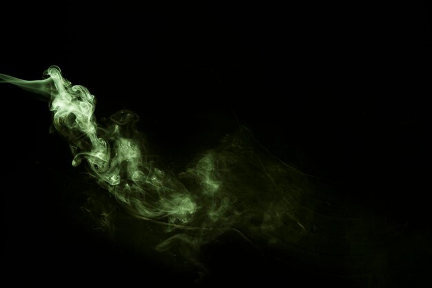 검은 배경 위에 불고 녹색 어두운 연기