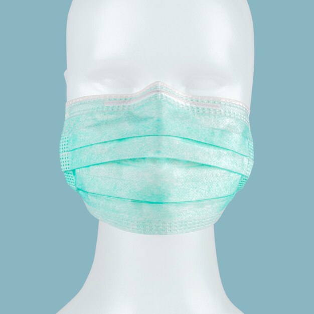 Green disposable surgical face mask on a mannequin