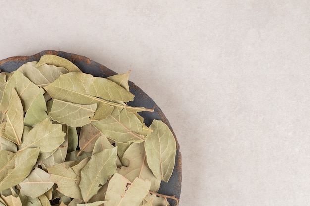 Free photo green dried bay leaves on a wooden platter.