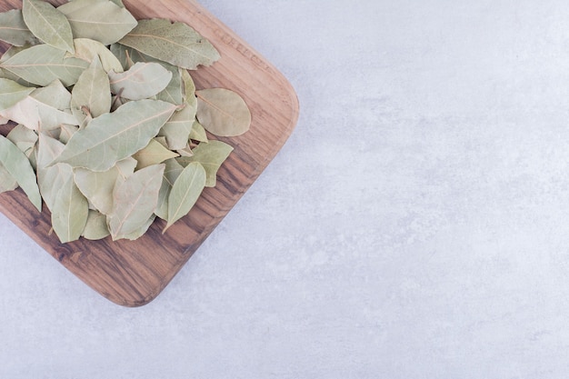 Green dry bay leaves on a wooden platter