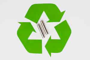 Бесплатное фото Зеленый экологический символ переработки и использованные батареи