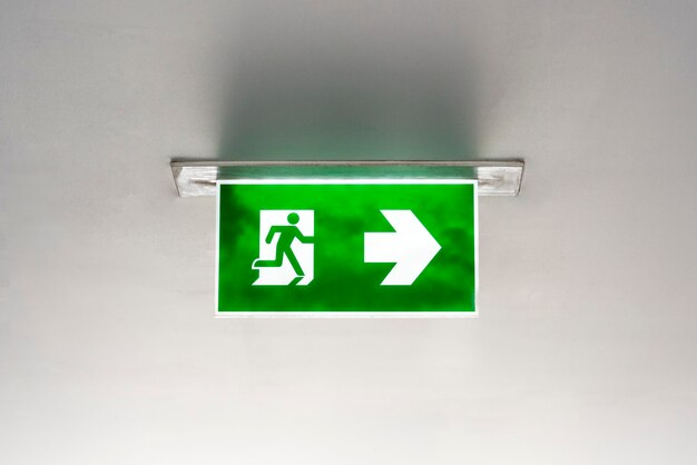 Green emergency exit sign on the ceiling