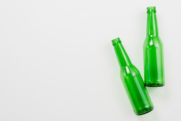 Green empty bottles on white background