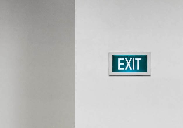 Green exit sign on a white wall