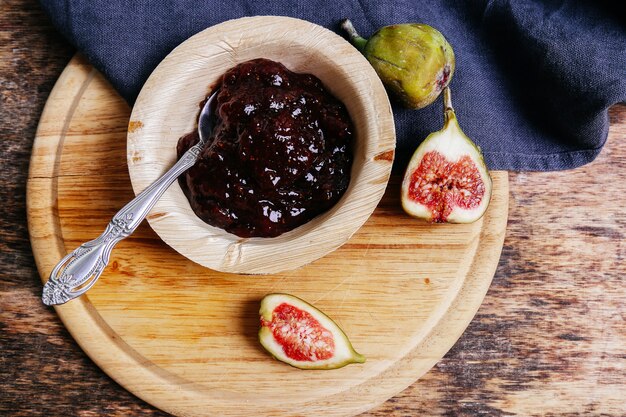 Green fig with jam on rustic table