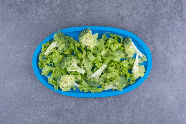 Green fresh broccoli isolated on blue surface