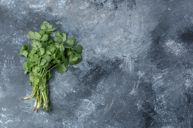 Green fresh parsley on marble background.