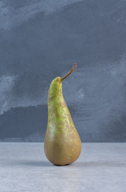 Green fresh pear stand on grey background. 