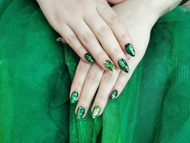 Free photo green gel nail extensions with gold foil