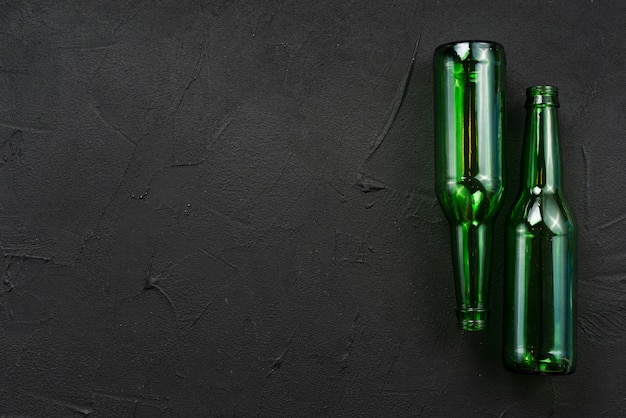 Green glass bottles laying on black background