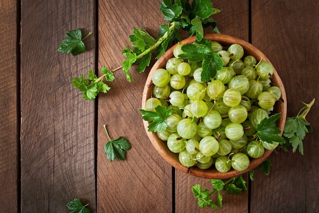 Free photo green gooseberries in a wooden bowl