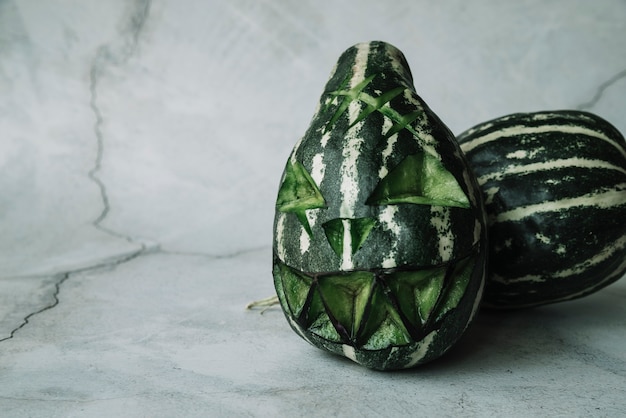 Free photo green gourds with carved scary face