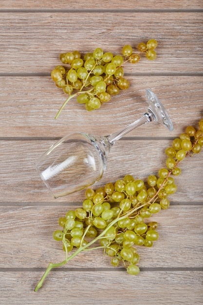 Green grapes with an empty wine glass around. 