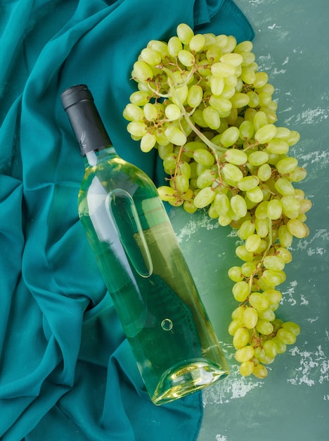 Free photo green grapes with wine on plaster and textile,