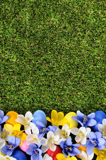 Green grass with easter eggs with flowers