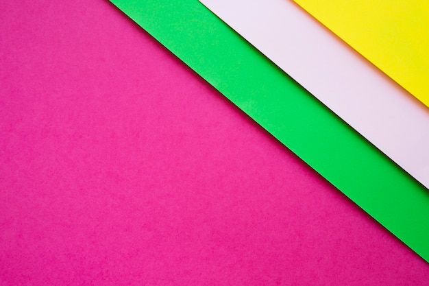 Зеленый; серые и желтые картонные бумаги на розовом фоне