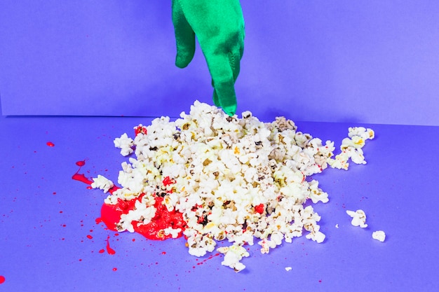 Green hand touching popcorn