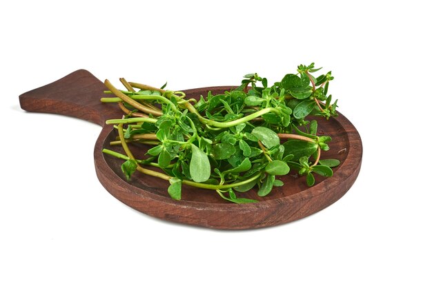 Green herbs on a wooden platter.