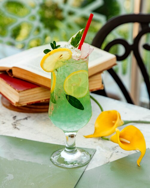 Green lemon cocktail with ice and lemon slices