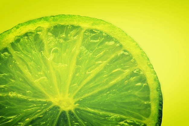 Free photo green lemon in a yellow background