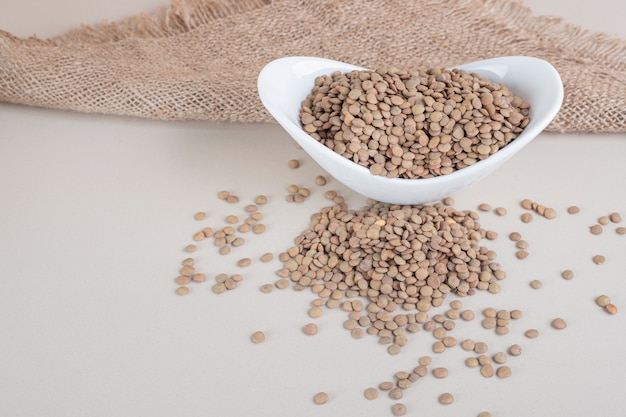 Green lentil beans in a ceramic bowl .