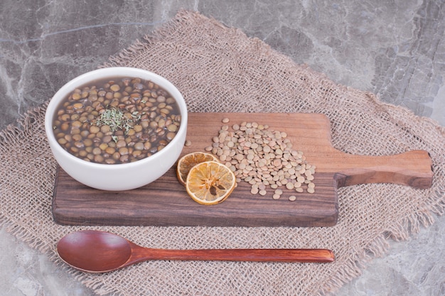 Free photo green lentil beans soup in broth in a white plate.