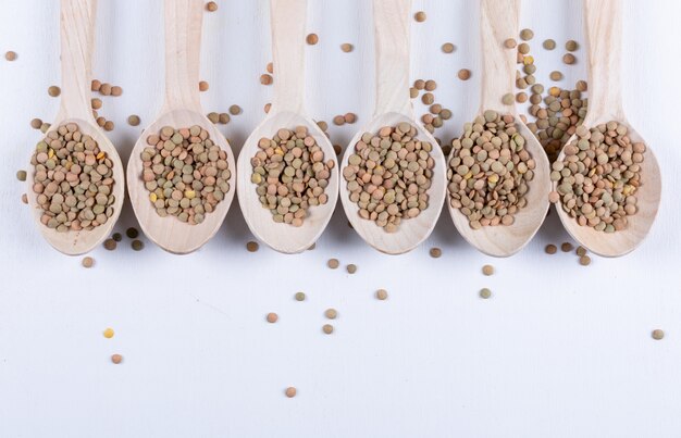 Green lentils in a wooden spoon