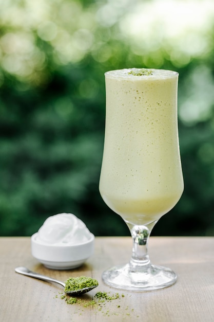 Зеленый молочный коктейль с мороженым на террасе.