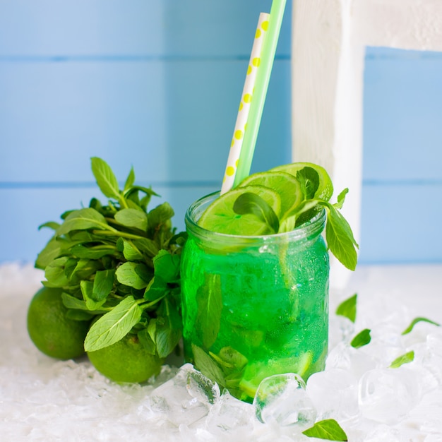 Green mojito served in glass jar garnished with lime and mint