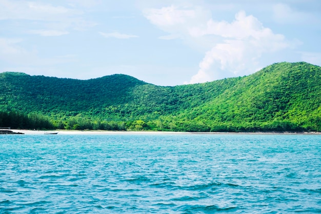 Green mountain in front of blue sea