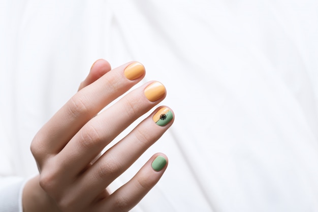 Green nail design. Female hand with dandelion nail art.