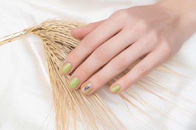 Green nail design. Female hand with glitter manicure.