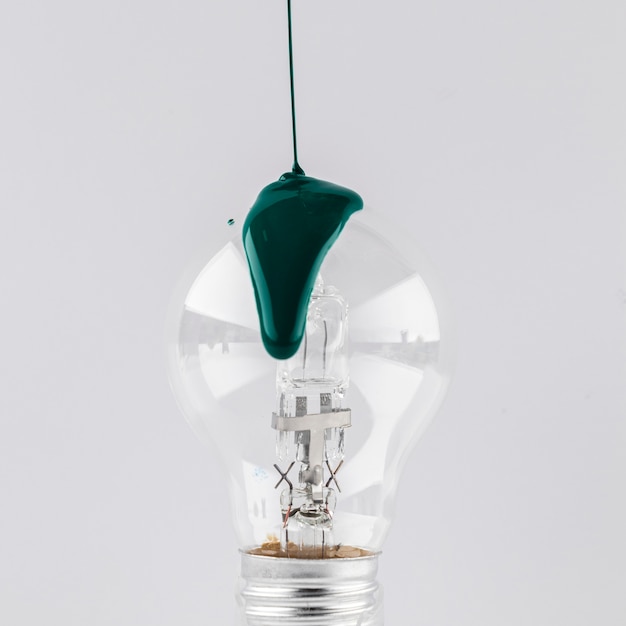 Green painted poured on light bulb