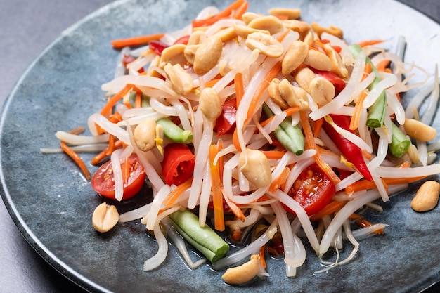 Foto gratuita insalata di papaya verde som tam thai su sfondo di ardesia nera