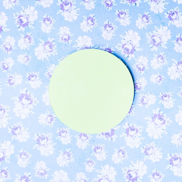 Free photo green paper circle frame on vintage floral backdrop