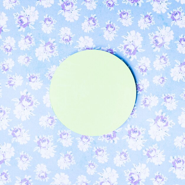 Green paper circle frame on vintage floral backdrop