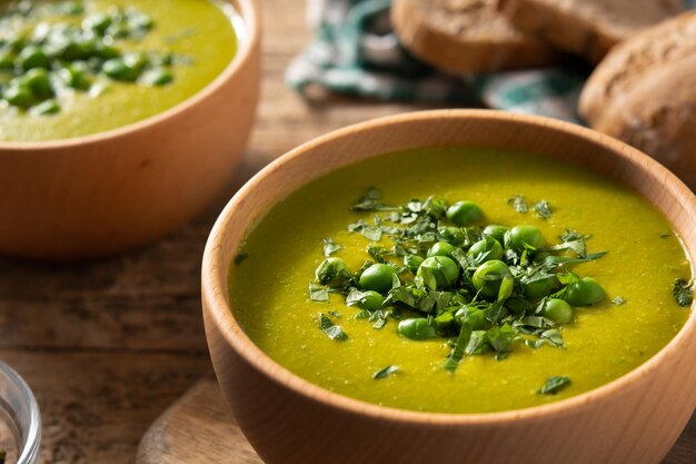 Суп из зеленого горошка в деревянной миске