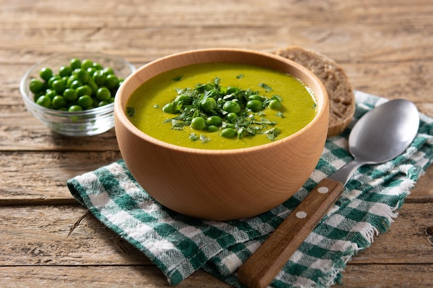 Суп из зеленого горошка в деревянной миске