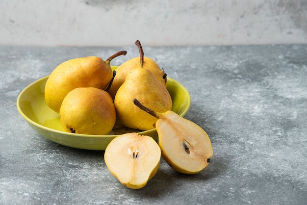 Green pears in a ceramic plate. 