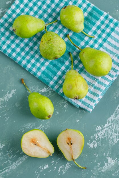 Green pears on plaster and kitchen towel. flat lay.
