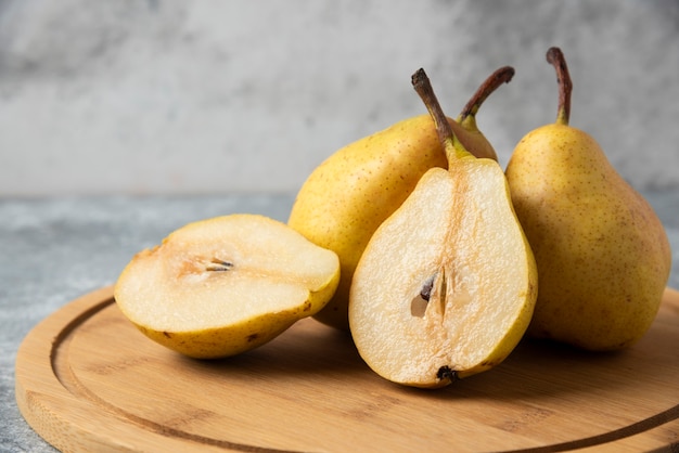 Free photo green pears on a wooden board.