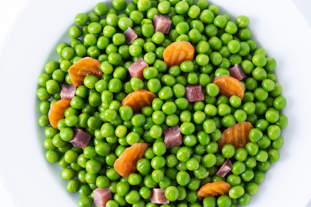 Green peas with serrano ham and carrot isolated on white background