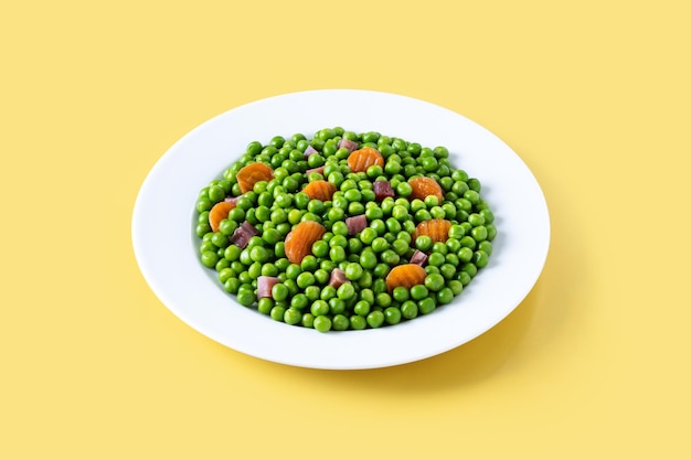 Foto gratuita piselli verdi con prosciutto serrano e carota su sfondo giallo