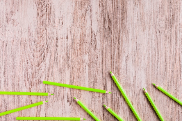 Бесплатное фото Зеленые карандаши на деревянной поверхности