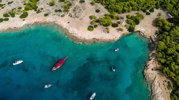 Green peninsula with yachts and boats near it in Greece