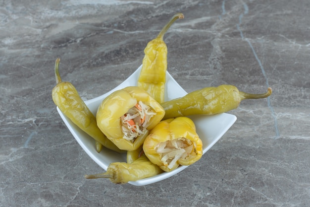 Green pepper filled with sauerkraut and hot peppers in white bowl